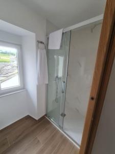 W łazience znajduje się przeszklony prysznic z oknem. w obiekcie Casa Cainzal w mieście Foz +21 zdjęć