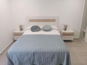 sypialnia z łóżkiem z 2 niebieskimi poduszkami w obiekcie Casa Cainzal w mieście Foz