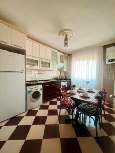 eine Küche mit einem karierten Boden sowie einem Tisch und Stühlen in der Unterkunft Seabird Suite Apart Hotel in Trabzon