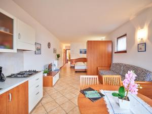 馬爾切西內的住宿－Appartamenti La Perla，厨房以及带沙发和桌子的客厅。