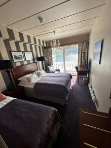 ソンダルにあるHofslund Fjord Hotelのベッド2台と窓が備わるホテルルームです。
