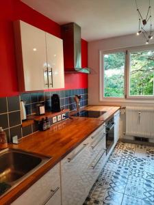 a kitchen with red walls and a wooden counter top at Chaleureux appartement. Dinan in Dinan