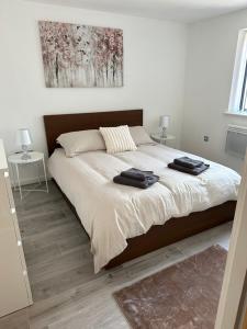 a bedroom with a large bed with two towels on it at 2bed luxury modern apartment in Swansea