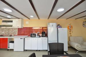 uma cozinha com armários brancos e um frigorífico branco em Casa Octaral em Eforie Nord
