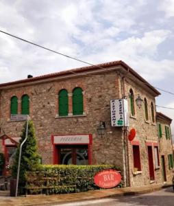 un edificio de ladrillo con ventanas verdes y un cartel en él en Residenza Tito Livio Teolo, en Teolo