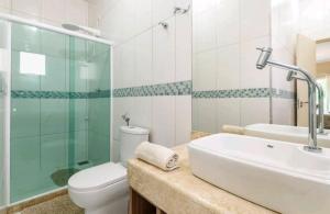 uma casa de banho com um WC, um lavatório e um chuveiro em Linda casa com piscina aquecida e ar condicionado a 1h do RJ em Guapimirim