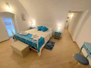 a bedroom with a large bed with blue pillows at La Dimora nel Borgo in Locorotondo