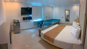Habitación de hotel con cama y TV en Infinity Hotel, en Medellín