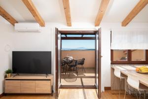A television and/or entertainment centre at Cesare Apartment, with Swimming pool and Sea view