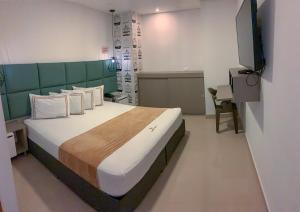 1 dormitorio con 1 cama grande y cabecero verde en Infinity Hotel, en Medellín