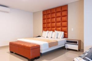1 dormitorio con 1 cama grande y cabecero acolchado en naranja en Infinity Hotel, en Medellín