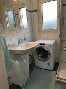 a bathroom with a sink and a washing machine at Appartement de 3 pièces, dans la maison familial à Morat-Murten, Fribourg-CH in Murten