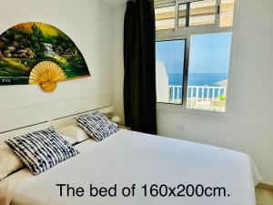 ein Schlafzimmer mit einem Bett und einem großen Fenster in der Unterkunft AMADORES BALCONY - WITH OCEAN VIEW. in Amadores