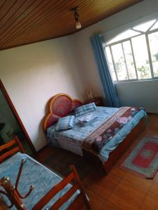 a bedroom with a bed and a window at Pousada Colina Da Neve in São Joaquim