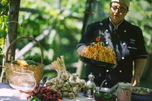 a man standing next to a table with a bowl of pasta at Agriturismo Il Tintore in Tramonti