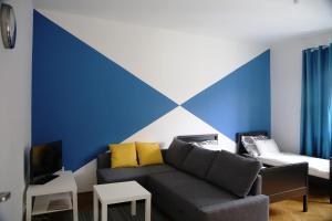 オストラヴァにあるApartmany Ostravaの青と白の壁のリビングルーム(ソファ付)