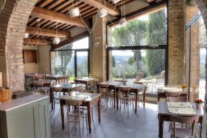 a restaurant with tables and chairs and large windows at Salvadonica in San Casciano in Val di Pesa