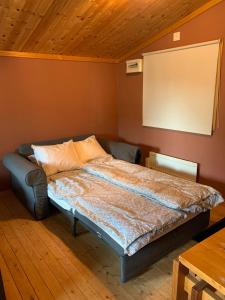 una camera con un letto in una stanza con soffitto in legno di The Pink Cabin a Tyfta