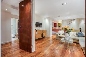 a living room with a couch and a tv at Modern 2 bedrooms 2bathrooms behind Nobu hotel in London