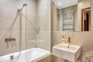uma casa de banho com um chuveiro, um lavatório e uma banheira em Modern 2 bedrooms 2bathrooms behind Nobu hotel em Londres