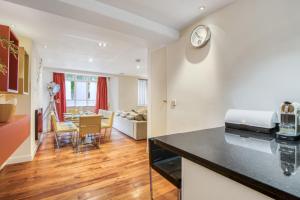 a kitchen and living room with a clock on the wall at Modern 2 bedrooms 2bathrooms behind Nobu hotel in London