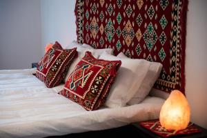 uma cama com almofadas vermelhas e brancas em Bright & Spacious Apartment in Main Central Zone em Sarajevo