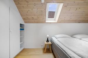 a bedroom with a white bed and a window at Charming Rooftop Apartment in Heart of Stavanger in Stavanger
