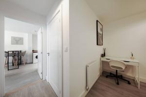 a white room with a desk and a chair at Stylish Well-Furnished Haven. in South Ockendon