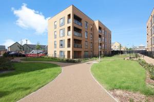 a building with a walkway in front of a park at Stylish Well-Furnished Haven. in South Ockendon