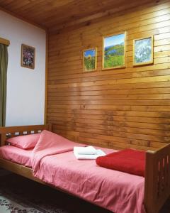 a bedroom with a bed with a wooden wall at Household Nikolic - Andrijevica, Montenegro in Andrijevica