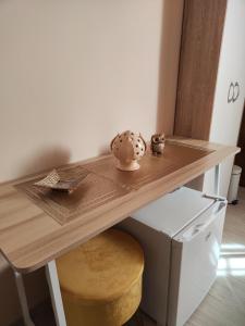 una mesa de madera con un taburete de madera bajo un escritorio en b&b La Madonnina en Presicce