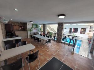 Habitación con mesas, sillas y balcón. en Ma Garbo Hotspring Private Resort, en Calambá
