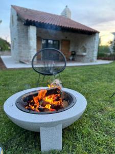 a fire pit in the grass in front of a house at Villa Ondina - private pool in Brtonigla
