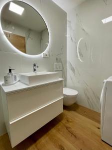 a white bathroom with a sink and a mirror at Villa Ondina in Brtonigla