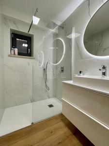 a white bathroom with a shower and a sink at Villa Ondina in Brtonigla