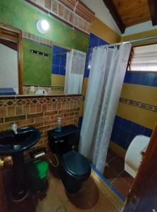 bagno con servizi igienici neri e lavandino di CABAÑAS VILLA EMILY a Curití