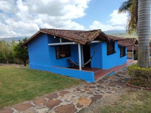 a blue house with a palm tree at CABAÑAS VILLA EMILY in Curití