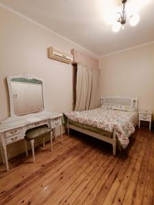 a bedroom with two beds and a vanity and a mirror at Nile view apartment in Cairo