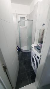 a bathroom with a washing machine and a mirror at Orik Apartament in Vlorë