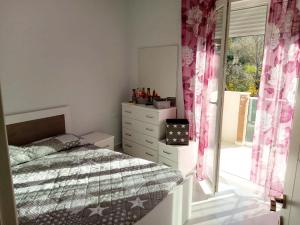 a bedroom with a bed and a dresser and a window at Orik Apartament in Vlorë