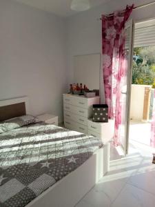 a bedroom with a bed and a dresser and a window at Orik Apartament in Vlorë