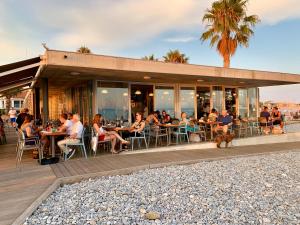 a group of people sitting at tables outside of a restaurant at Front sea Luxury in Cagnes-sur-Mer