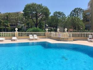 a swimming pool with two chairs and a fence at Front sea Luxury in Cagnes-sur-Mer