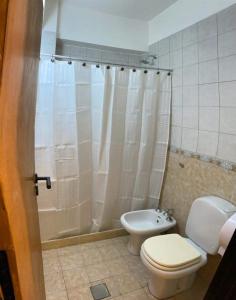 y baño con aseo y cortina de ducha. en Canciller House Godoy Cruz en Godoy Cruz