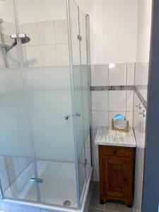 a bathroom with a glass shower with a wooden vanity at Ferienwohnung Hansezauber Lübeck in Lübeck +23 photos