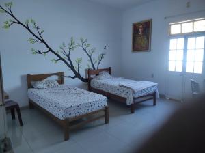 um quarto com duas camas e uma árvore em 717 Pizarro guesthouse em Trujillo
