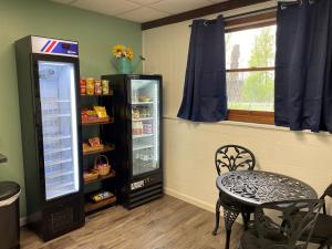 um quarto com um frigorífico, uma mesa e uma janela em Parkside Inn em Ellison Bay