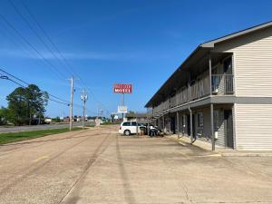 a white van parked in front of a building at Brass Door Motel in Gassville