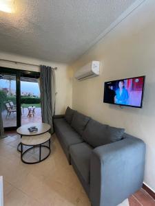 een woonkamer met een bank en een tv bij la hacienda in Ras Sedr