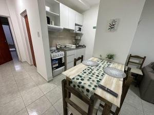 a kitchen with a table and a kitchen with a stove at DON SIMON Apart 2 - departamento nuevo in Esperanza